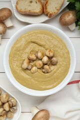 Delicious mushroom cream soup on white wooden table, flat lay