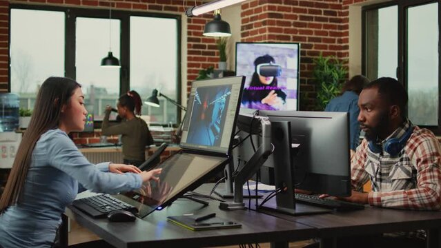 Employee game developer working in creative production department to create professional web content in office. Asian woman developing 3D graphics components with engineering software