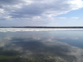 Obraz premium lake with ice reflecting the blue sky and clouds