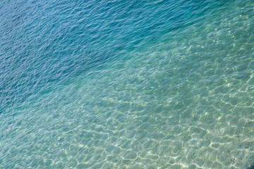 Marine water surface, sun's rays shimmer on water surface, diagonal lines, top view