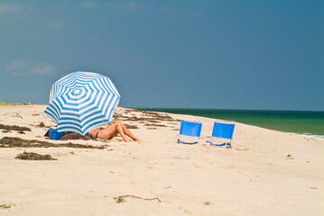 Woman suntanning on a beach.