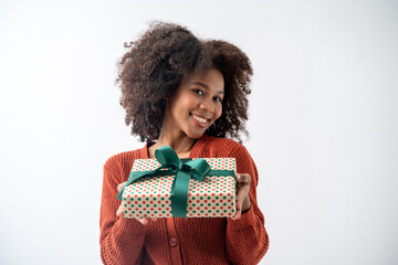Portrait of young attractive african american woman with curly hair presenting gift box in studio...