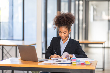 Young African American businesswoman wotk, black woman in afro hair business woman working on laptop and do document, tax, exchange, finance, accounting,