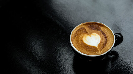 hot coffee latte art heart shape on black table