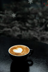 hot coffee latte art heart shape on black table