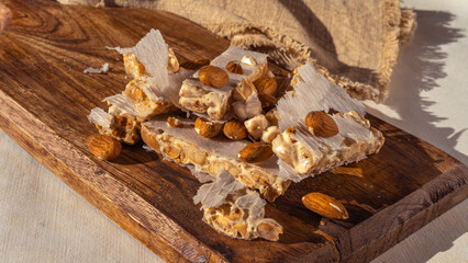 Heap of Almond Spanish turron dessert slices with nuts on on wooden desk