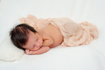 Obraz na płótnie Canvas newborn baby sleeping in blanket on bed