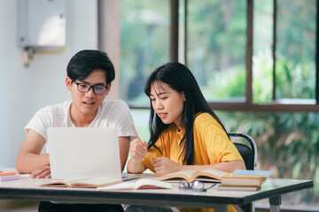 Young asian students campus helps friend catching up and learning.