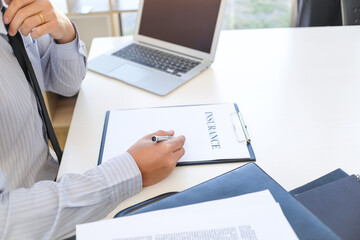 Sales manager giving advice application form document, considering mortgage loan offer for car and house insurance.