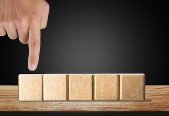 Business person pointing on wooden block or cube