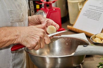 Chef cuts ginger into bowl for cooking