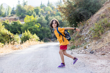 boy with a backpack dancer. smiling boy on a hike.