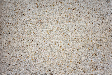 texture of a house facade made of gray concrete with small stones. A rough plaster on a wall.