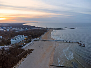 Aerial view. Seascape. The setting sun. Beach, sand, sea , water , waves. Winter season. Photo from a drone.