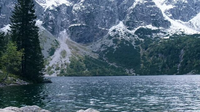 Tatra National Park, Poland. Famous Mountains Lake Morskie Oko Or Sea Eye Lake In autumn. Snow covered mountain peaks on background. Blue water nature landscape 4k
