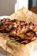 Fried meat on wooden skewers.Tasty kebabs in plum sauce