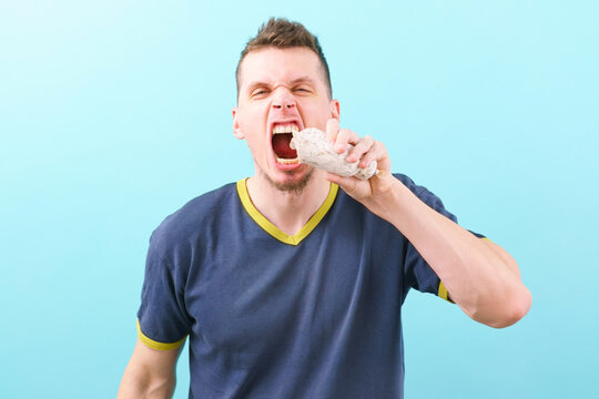 An angry an gungry man trying to eat white sausage on a blue background. Sausage. Spanish. Hand. Old. Background. Food. Spain. Thin. Buffet. Fat. Tripe. Pork