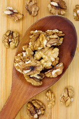 walnuts with wooden spoon on fabric background