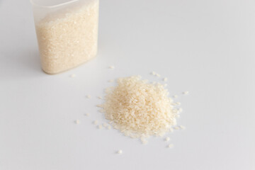 白い米粒とプラスチックの計量カップ
