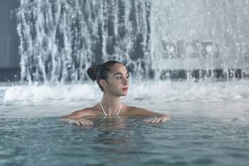 Young woman swimming in pool in spa