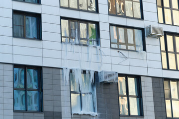 Fototapeta na wymiar icicle on the windows and glass of a modern house due to an accident in the heating system.