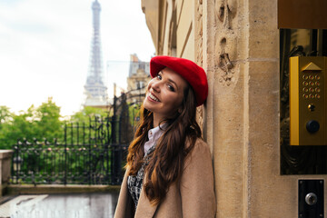 Beautiful young woman visiting paris and the eiffel tower. Parisian girl with red hat and...