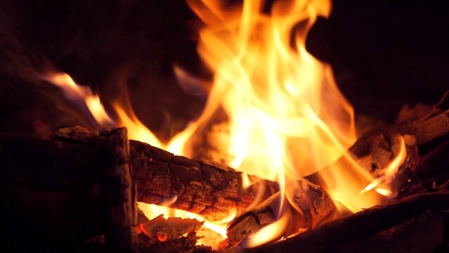 Beautiful footage of burning fire wood in the dark close up.