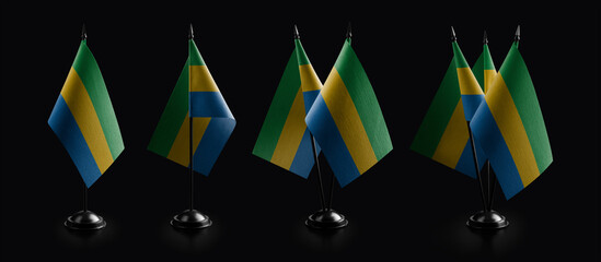 Small national flags of the Gabon on a black background