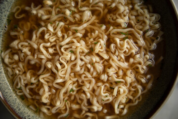 ramen noodles close-up. broth ramen macro photo. Asian instant noodles with spices soaked in water	