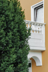 Fototapeta na wymiar House with a white balcony, surrounded by greenery.