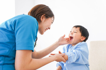 子どもを診察する若い看護師