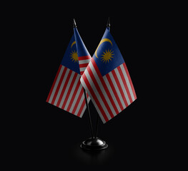 Small national flags of the Malaysia on a black background