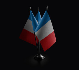 Small national flags of the France on a black background