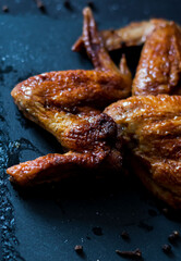 
Grilled spicy chicken wings with ketchup, on a dark background
