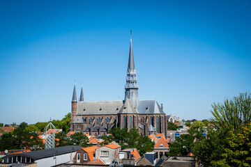 Historic Dutch architecture Saint Johns Church in Gouda overlooking the rooftops of the pretty town on a sunny summer day. The gothic building is a stunning attraction for tourists in the Netherlands