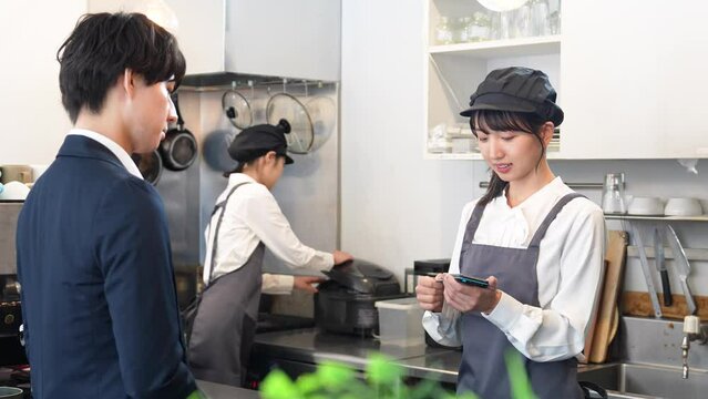 キャッシュレス決済をする若い男性客