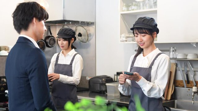 キャッシュレス決済をする若い男性客