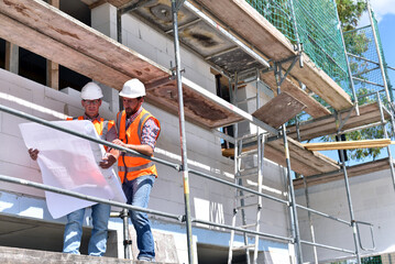construction manager and architect on site during the construction of a house - planning and...