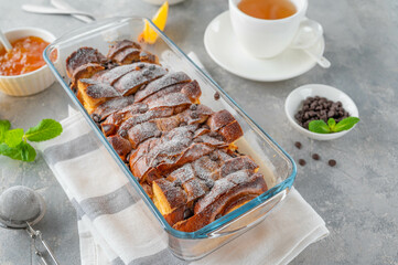 Homemade bread pudding with chocolate chips on a gray concrete background. Selective focus, copy space.