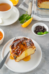 Homemade bread pudding with chocolate chips on a gray concrete background. Selective focus, copy space.