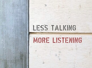 Line on wall separating two parts with text LESS TALKING MORE LISTENING,  to speak less and listen...