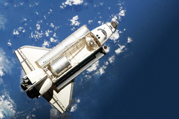 Space shuttle above the surface of the Earth. Elements of this image furnished by NASA