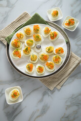 Gefüllte teuflische russische Eier mit Dill und orange Keta Lachs und gelb Saibling Kaviar auf Eierteller, Serviette grün, Silber Teller und Marmor Hintergrund hell