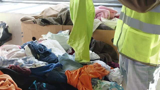 Textile recycling center. Sorting textiles into different fibres and material types by hand. Reduce, reuse and recycle program
