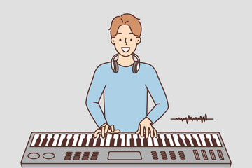 Smiling man play on synthesizer 