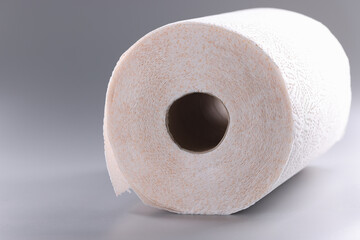 Roll of white toilet paper on gray background