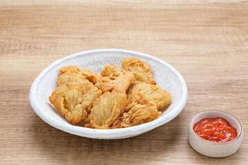 Crispy Fried Oyster Mushroom or Jamur Krispi served with chilli sauce, Indonesian snack
