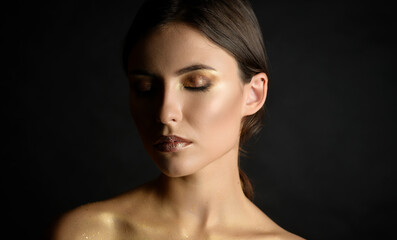 Fototapeta premium Close-up portrait of young woman with golden makeup.