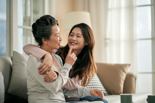 asian elderly mother and adult daughter enjoying good time together