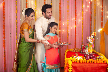 Traditional Indian family worshiping Lord Krishna on Krishna Janmashtami - Festival concept. Stock...